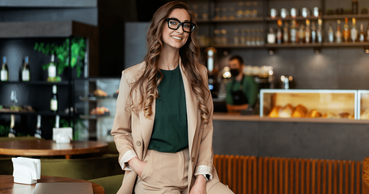 Smiling businesswoman in a cafe, representing flexible financing solutions for small businesses with bad credit.
