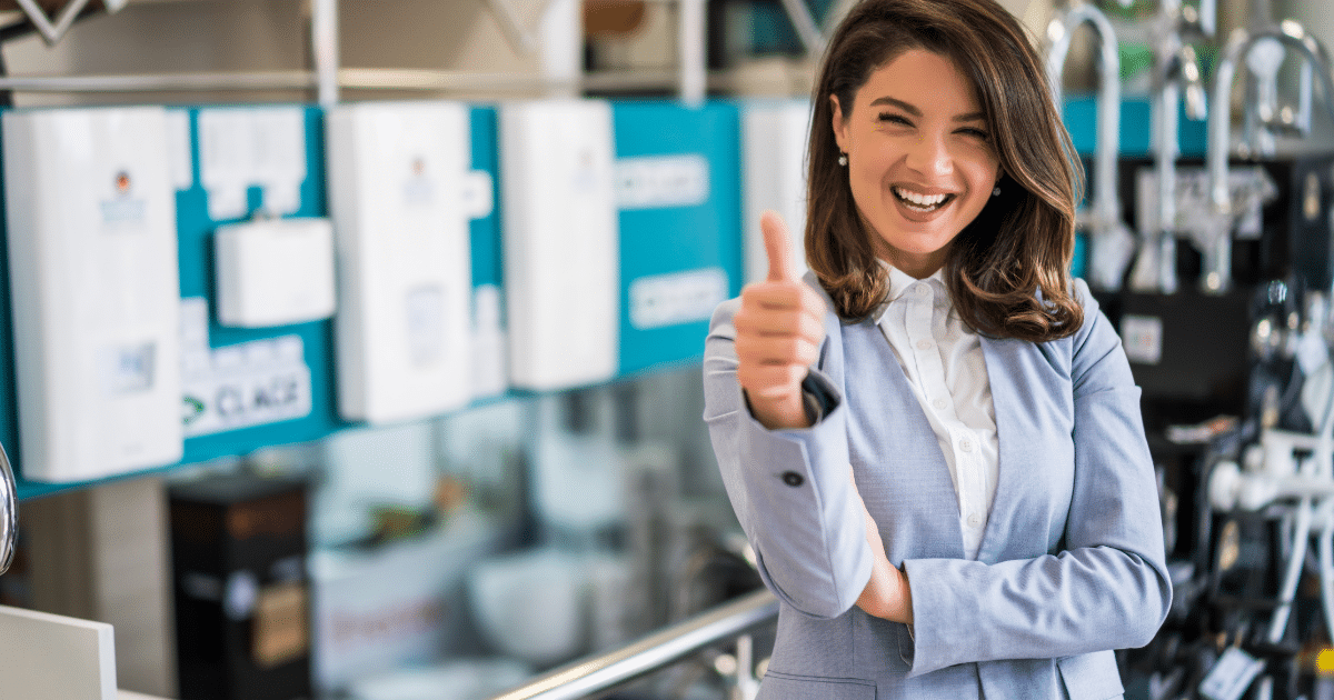 Smiling businesswoman giving a thumbs up in a retail environment, representing small business success and unsecured credit lines.