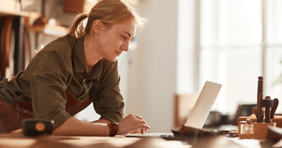 Woman working on a laptop in a workshop, exploring unsecured business loans and credit options for small businesses.