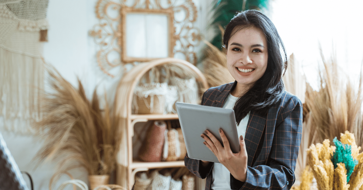 Smiling businesswoman holding a tablet, representing merchant cash advances and business growth solutions.