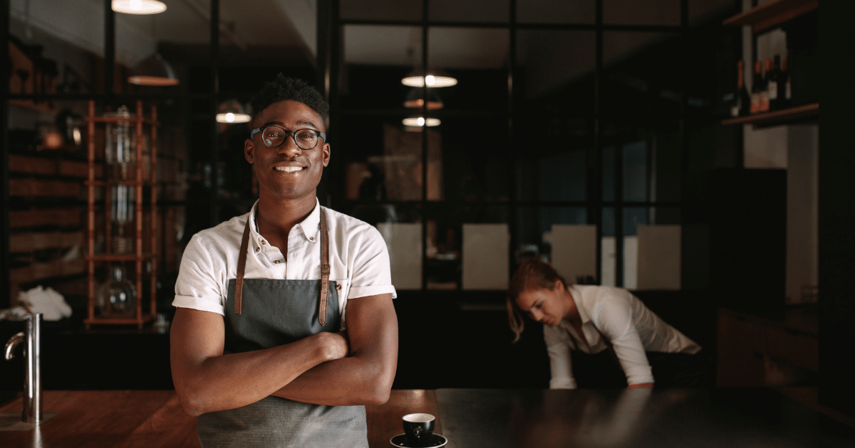 Smiling small business owner in a cafe, showcasing the benefits of flexible lines of credit for growth and cash flow management.