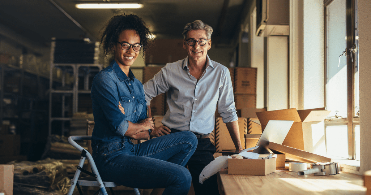 Business partners discussing merchant cash advance strategies in a warehouse, focusing on financial growth and funding solutions.