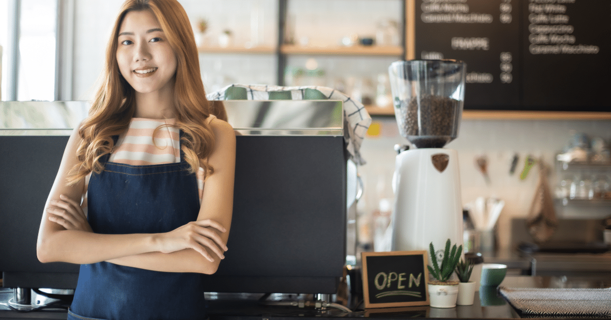 Smiling business owner in a cafe, showcasing growth potential with unsecured lines of credit for small businesses.