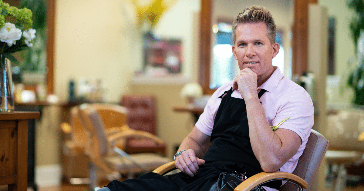 Small business owner in a salon, exploring financing strategies like credit cards and angel investors for growth.