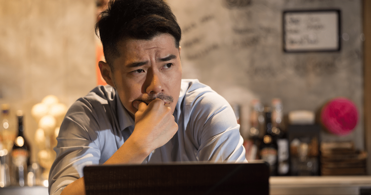 Business owner contemplating flexible factoring solutions for small business financing in a bar setting.