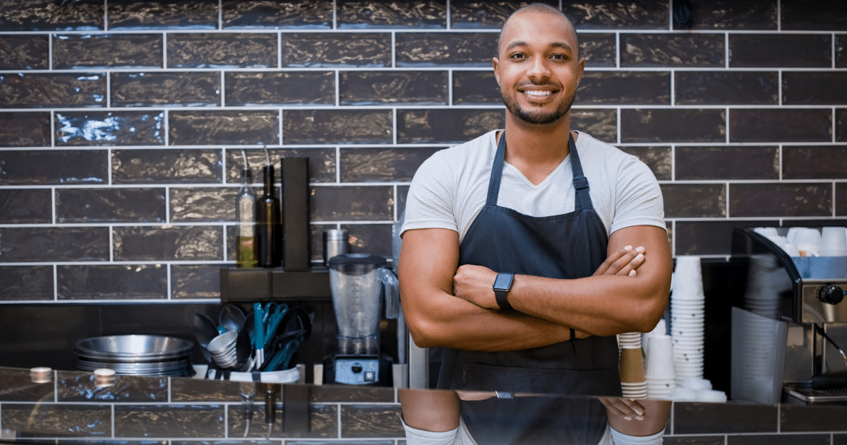 Smiling small business owner in a cafe showcasing confidence and readiness for success in securing a small business loan.