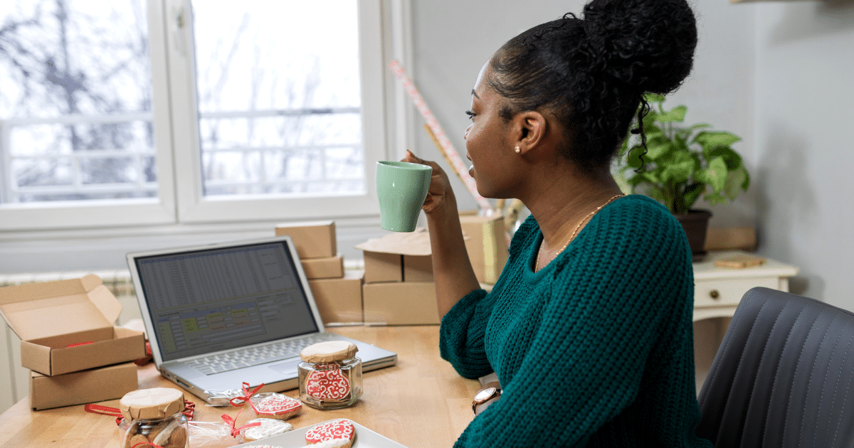 Business owner analyzing growth strategies with Johari's Window model, coffee in hand, surrounded by packages and a laptop.