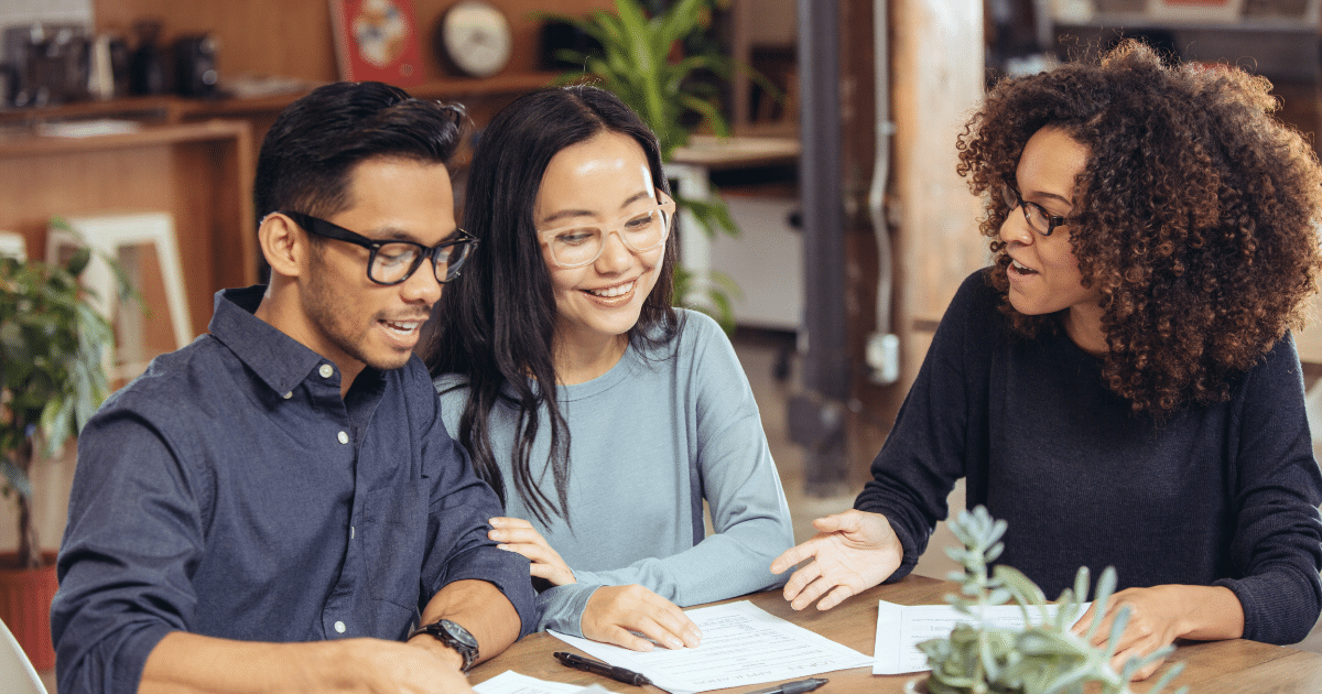 Diverse group discussing small business funding options with documents on the table in a collaborative workspace.