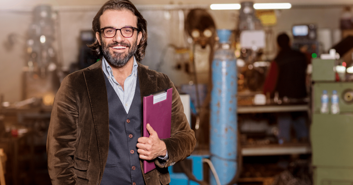 Smiling business owner in a workshop, showcasing successful franchising and business growth strategies.