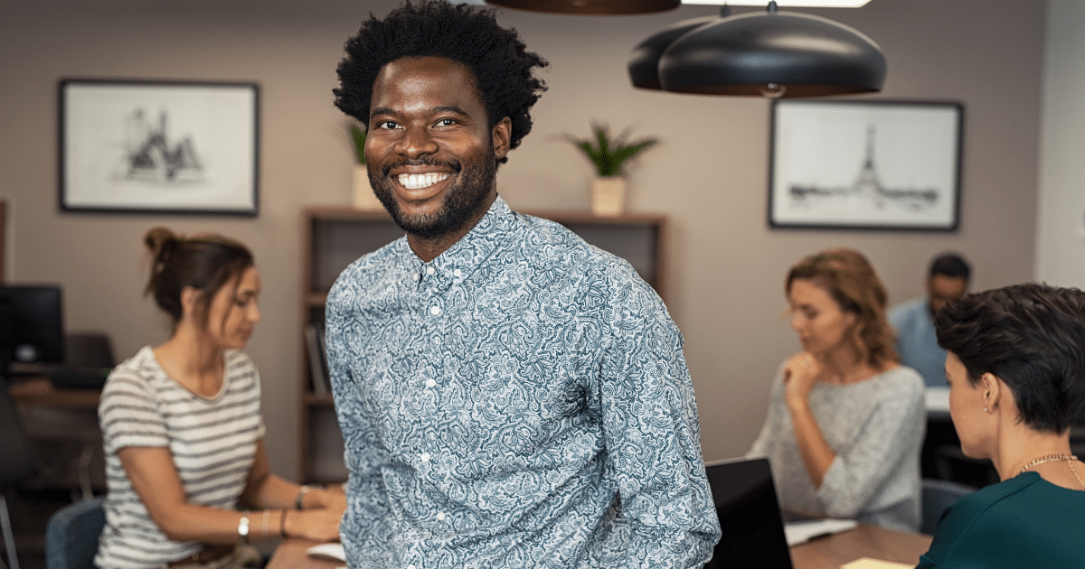 Smiling businessman in a modern office, representing flexible purchase order loans for business growth.