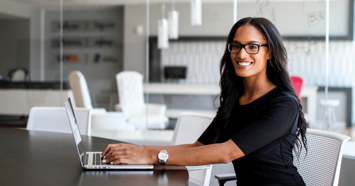 Professional woman using a laptop in a modern office, representing government purchase order financing solutions.