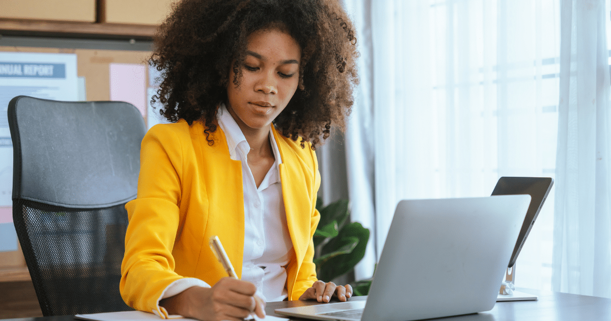 Business owner writing notes while planning New Year’s resolutions for business growth and success.