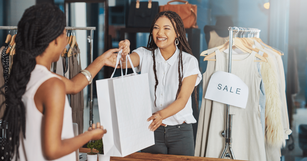 Happy customers receiving purchases in a retail store, highlighting small business success and cash flow solutions.