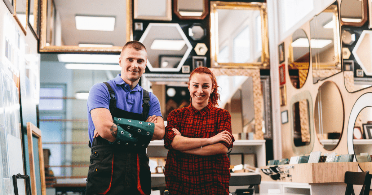 Small business owners in a frame shop smiling, representing essential tax deadlines and financial planning.