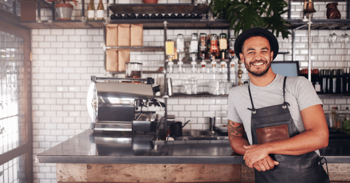 Smiling barista in a cafe, showcasing a welcoming atmosphere for small business owners considering 401k plans.