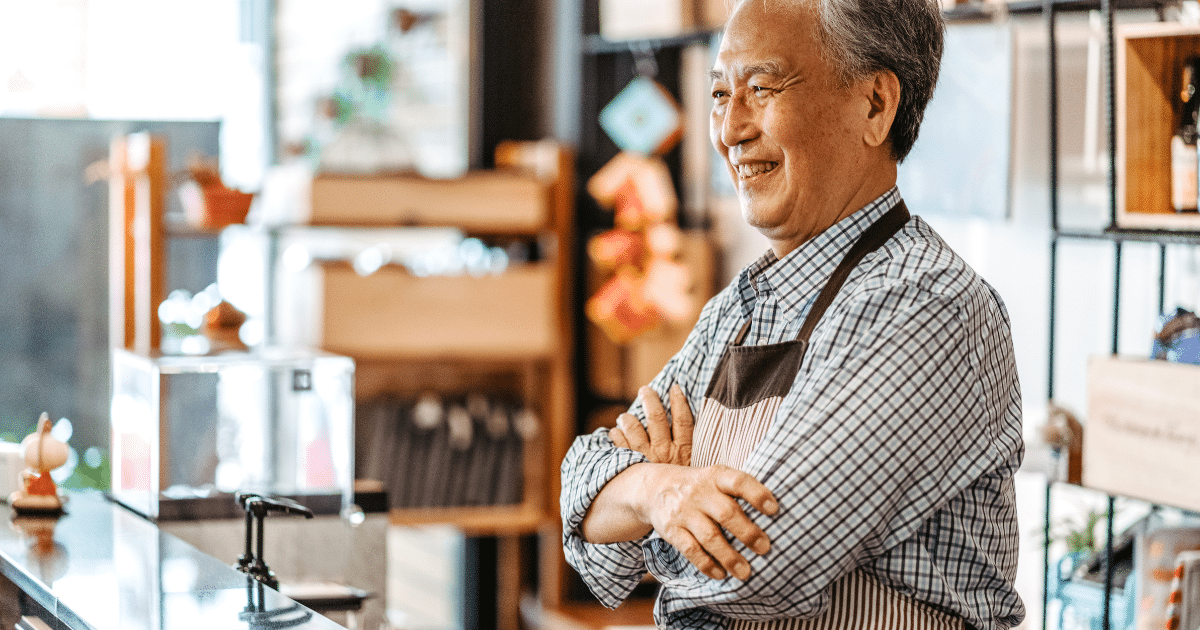 Smiling business owner in a cafe, representing accounts receivable funding for cash flow enhancement and business growth.