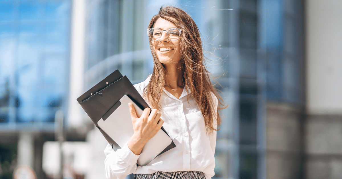 Smiling businesswoman holding a clipboard, representing expert loan consultation for small business growth.