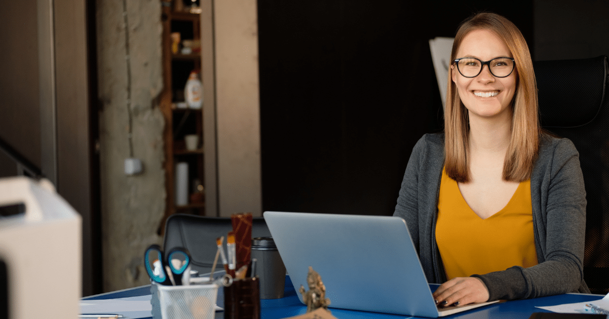 Smiling woman in an office setting, promoting small business growth through essential SEO tips and strategies.