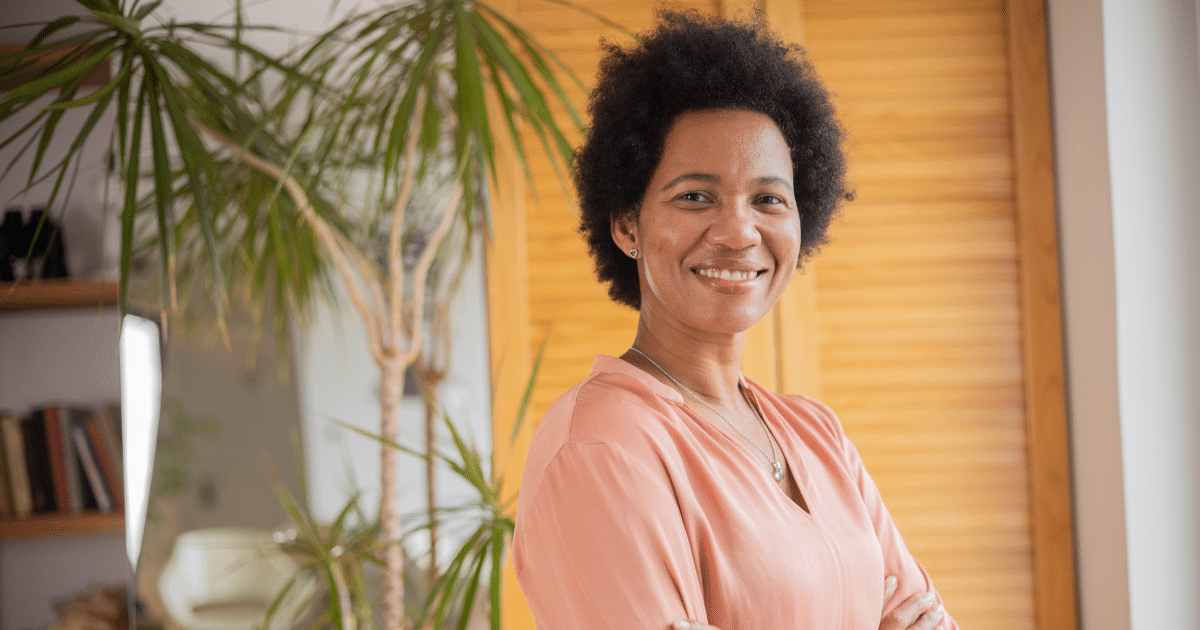 Smiling woman in a restaurant setting, emphasizing customer service and employee performance improvement strategies.