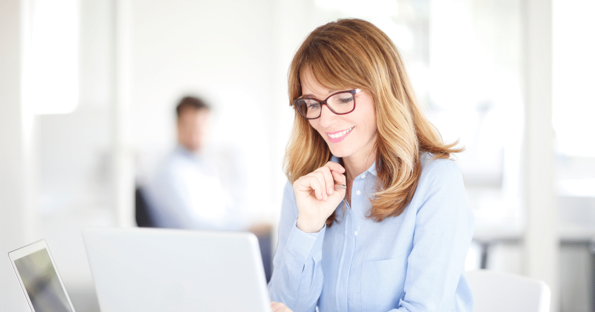 Smiling businesswoman using CRM software on a laptop, exploring small business innovations and marketing automation.