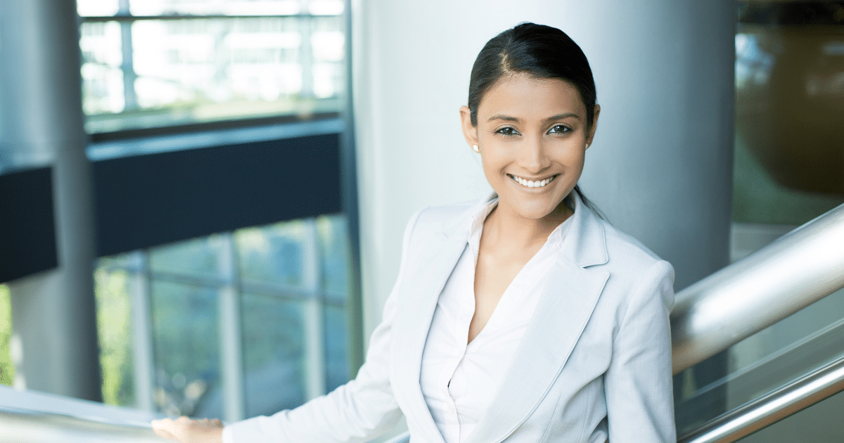 Professional woman smiling in a business setting, representing small business success and outsourcing strategies.