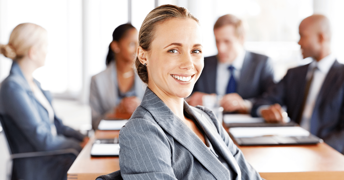 Professional woman smiling in a business meeting, representing effective marketing strategies and lead conversion.