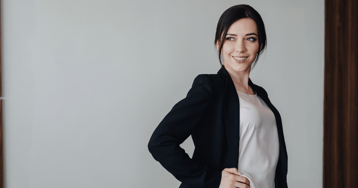 Professional woman in a blazer smiling, representing small business success and mobile marketing strategies.