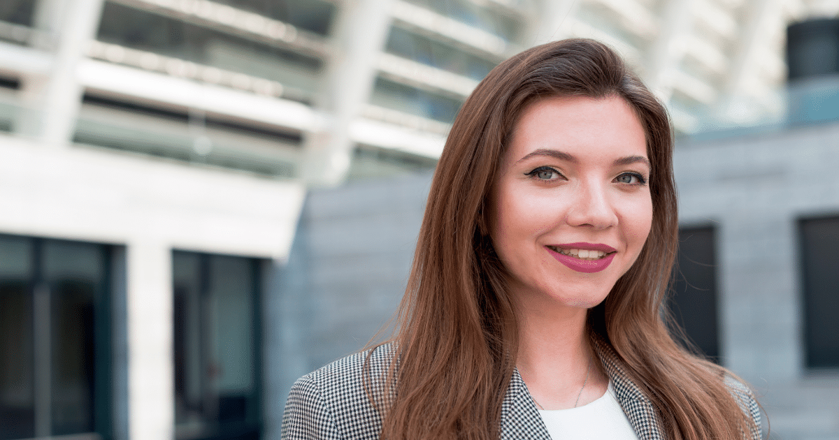 Professional woman smiling outdoors, representing customer retention strategies and business growth.