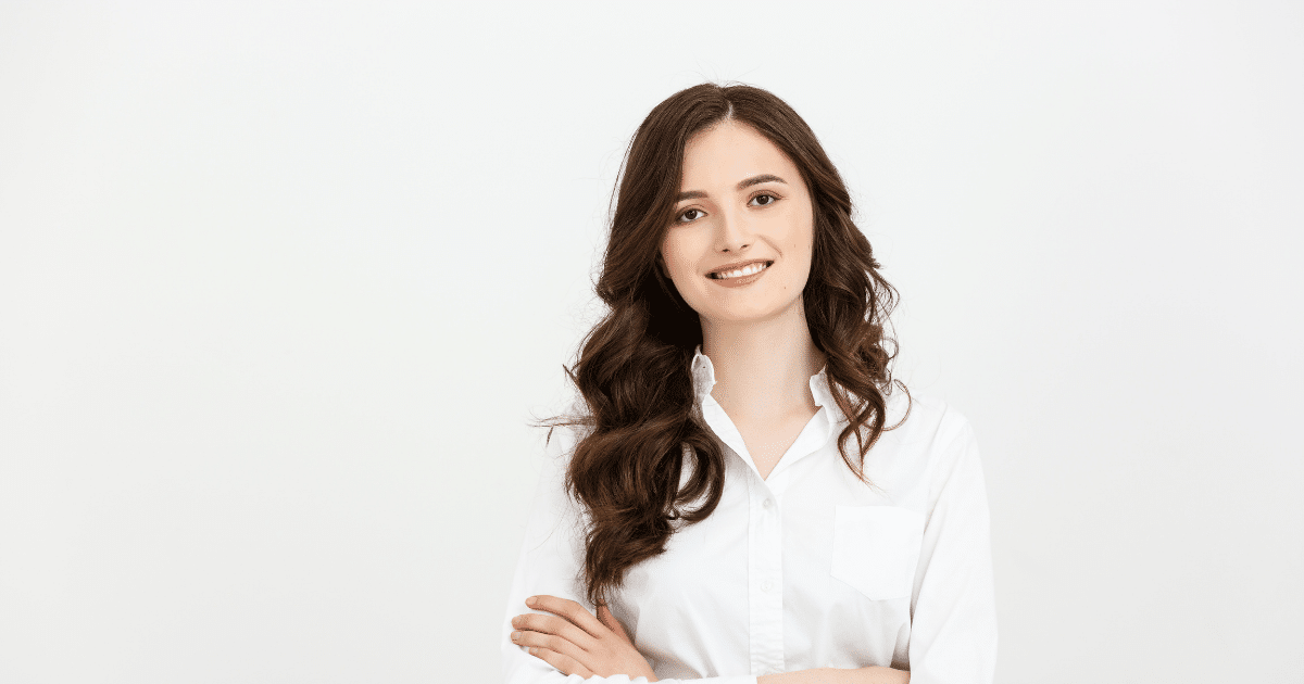 Professional woman smiling in a white shirt, representing business growth and effective press release strategies.