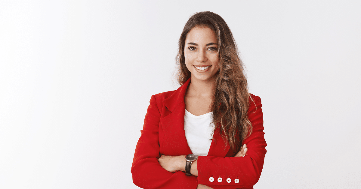 Smiling businesswoman in a red blazer promoting employee motivation and workplace positivity strategies.