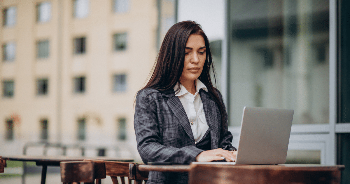 Business professional using marketing automation tools on a laptop outdoors, enhancing small business growth and efficiency.