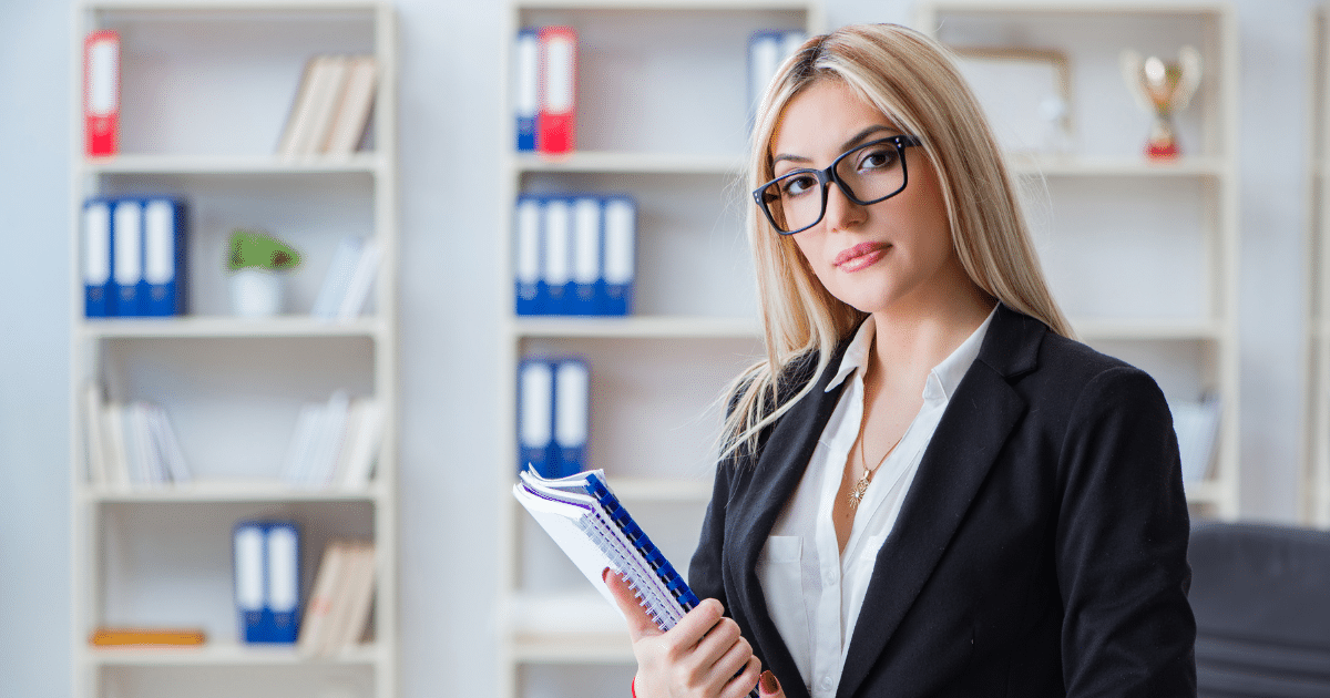 Professional woman in business attire holding notebooks, representing small business branding and strategy development.