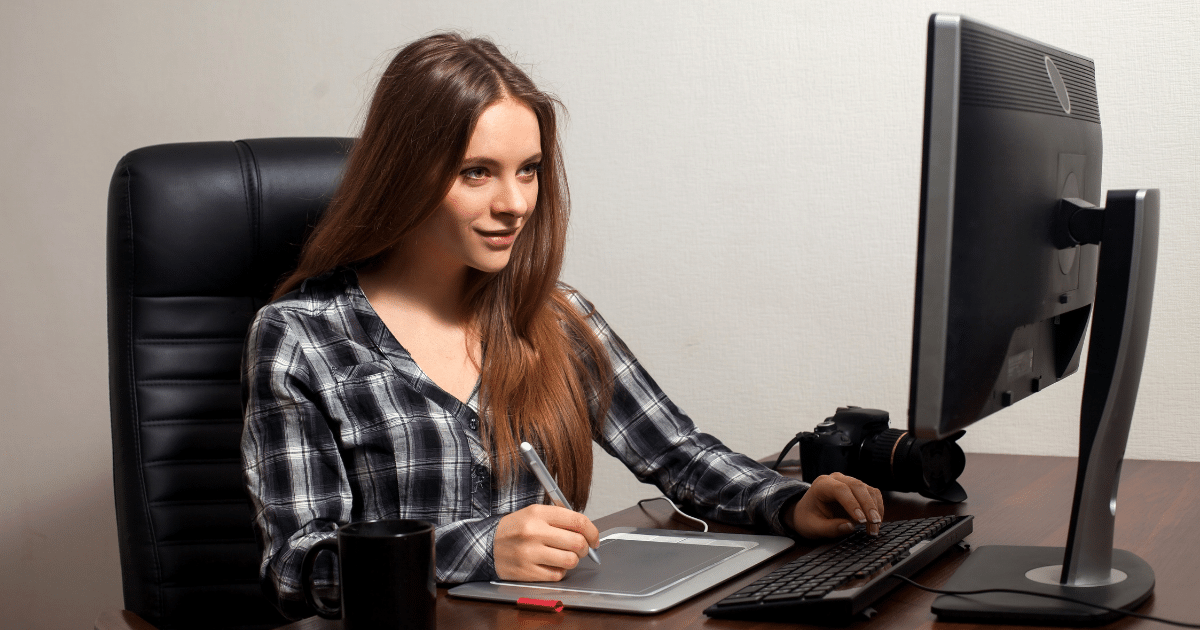 Young woman working on a digital tablet at her desk, focusing on small business growth and planning.
