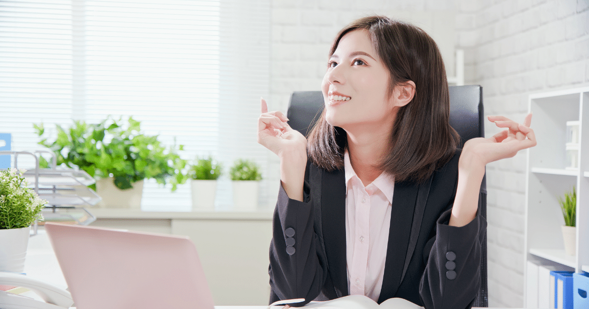 Businesswoman smiling and engaging in effective communication at her desk, promoting teamwork and collaboration.