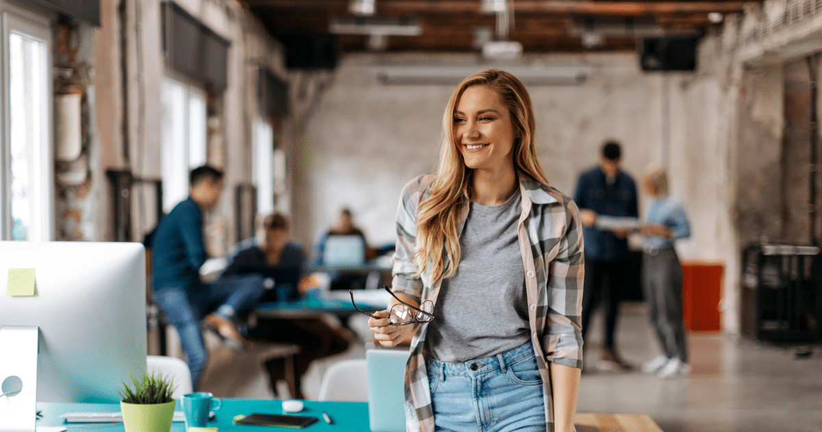 Smiling woman in a modern office, representing small business success and the benefits of small business loans.