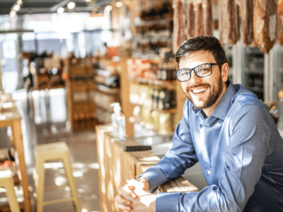 Smiling business owner in a retail store, showcasing flexible credit options for business growth and funding solutions.