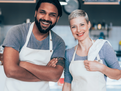 Smiling business owners in aprons representing small business growth and financing solutions for success.