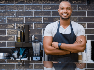 Smiling small business owner in a cafe showcasing confidence and readiness for success in securing a small business loan.