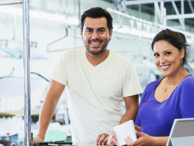 Business owners smiling in a service environment, showcasing teamwork and the importance of unsecured business lines of credit.
