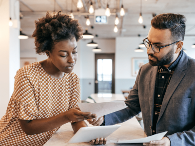 Business professionals discussing pharmacy equipment financing options in a modern office setting.