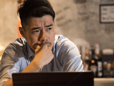 Business owner contemplating flexible factoring solutions for small business financing in a bar setting.