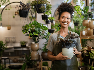 Smiling small business owner in an office, representing unsecured financing and support for SMB credit recovery.
