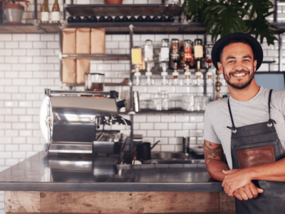 Smiling barista in a cafe, showcasing a welcoming atmosphere for small business owners considering 401k plans.