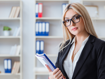 Professional woman in business attire holding notebooks, representing small business branding and strategy development.