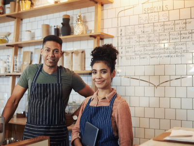 Small business owners in a cafe setting, showcasing productivity tips and teamwork in a vibrant workspace.