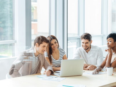 Group of young professionals collaborating on email marketing strategies for small business success in a modern office setting.