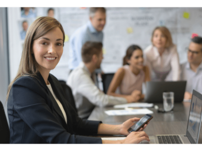 Business professional using a smartphone in a meeting, highlighting strategic credit card benefits for growth.