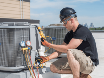 HVAC technician servicing air conditioning units, highlighting summer business growth and financing options for HVAC professionals.