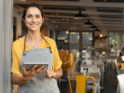 Smiling small business owner in a cafe, showcasing summer strategies for success and employee appreciation.